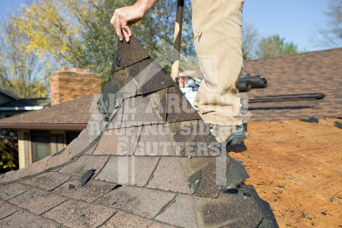 Roofer replacing shingles on a residential roof